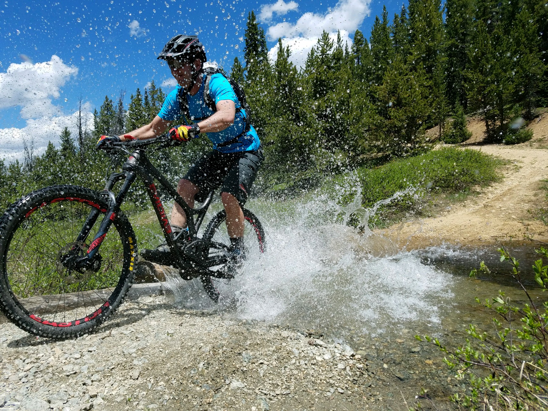 mountain biker rides through stream crossing